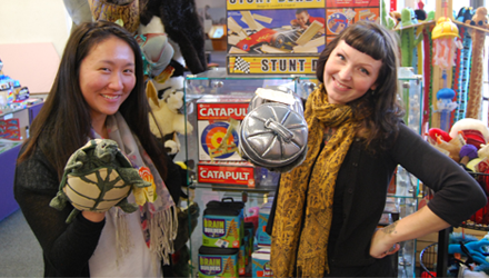 Connie and Chloe hold up items from the Discovery Corner Toy & Bookstore