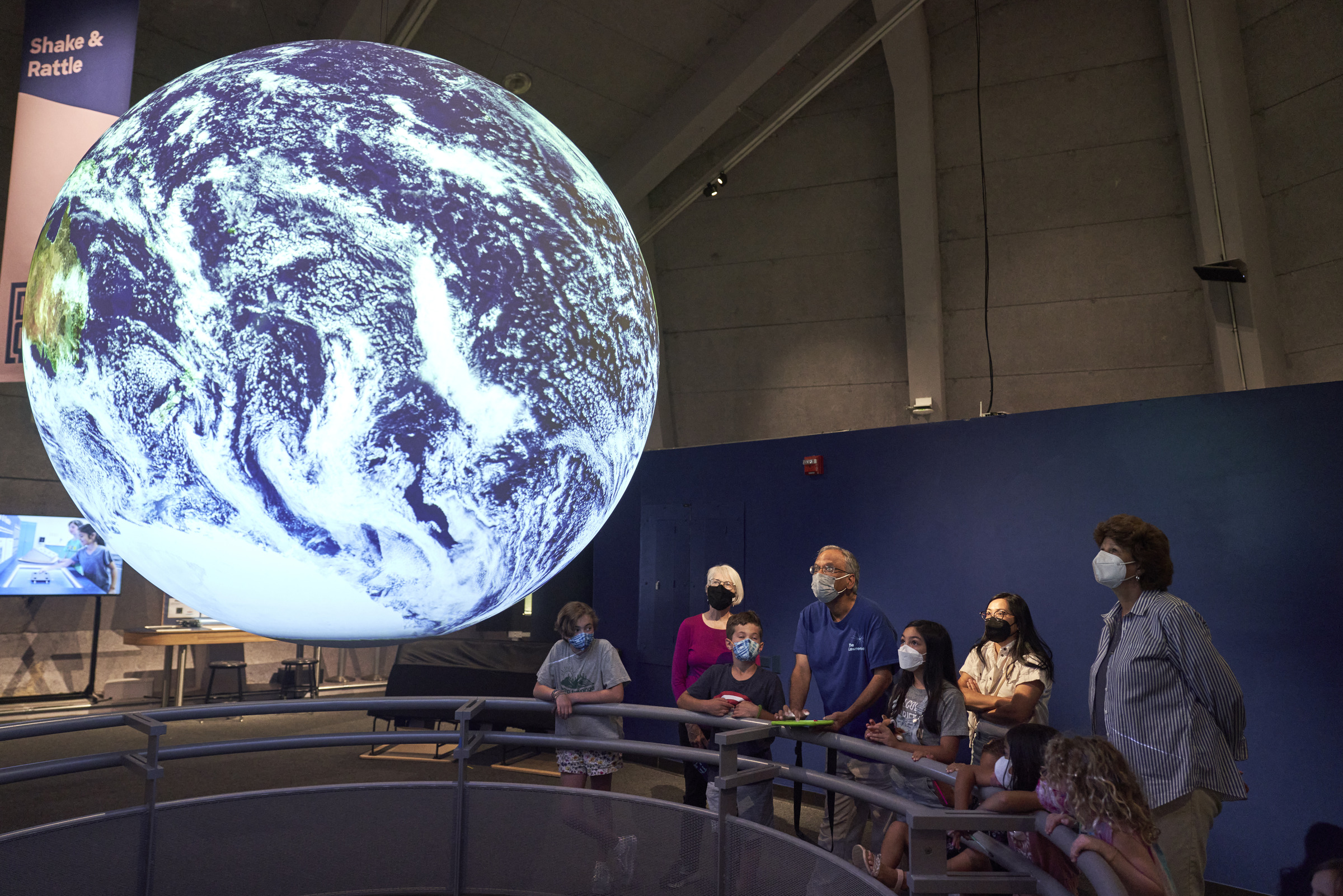 A group of visitors observing the globe projected on Science On A Sphere