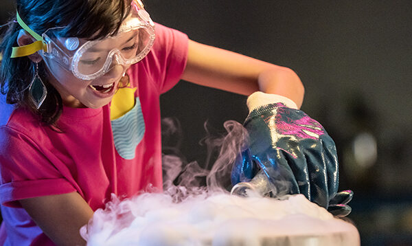 A young person performing a science experiment using dry ice.