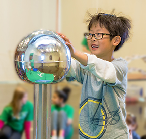 A child participating in a Science Show activity and learning about static electricity