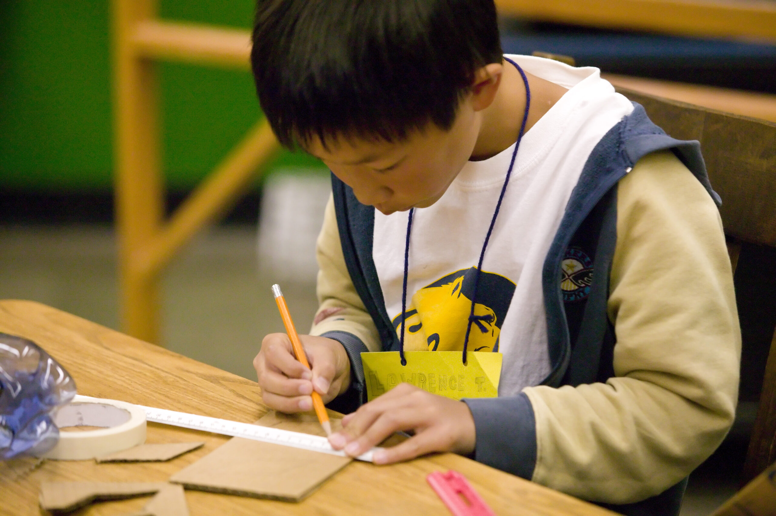 A student drawing a line with a ruler