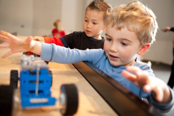 Two children with a model car at a science exhibit