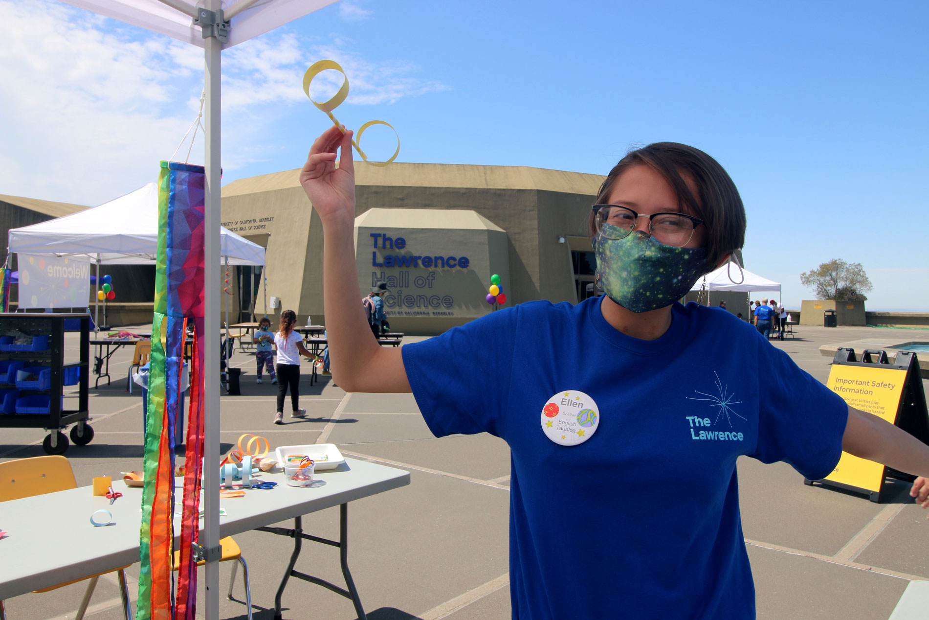 A staff member holding up a paper sculpture during Summer Fundays at The Lawrence
