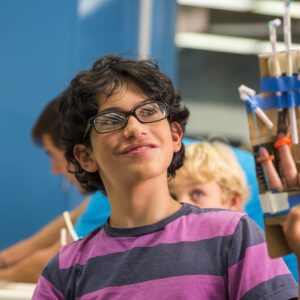 A student holding up his invention