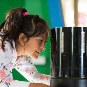 A child is participating in an activity in a physics exhibit at The Lawrence