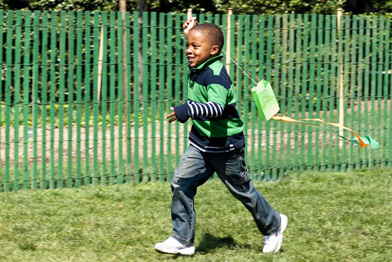 A young person running with a kite