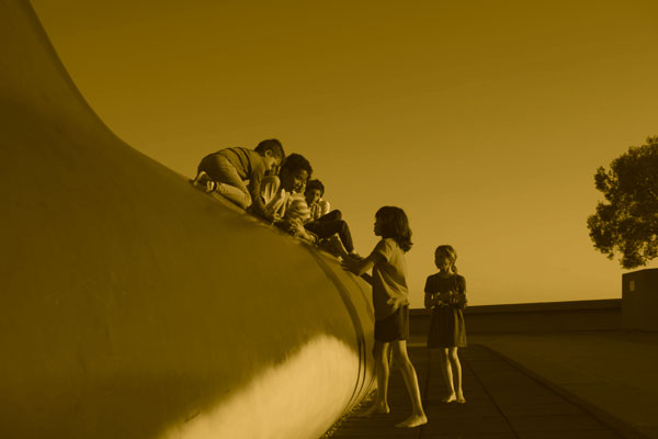 Children climbing on Pheena the Whale on the plaza at The Lawrence