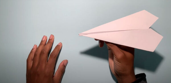 A pair of hands are about to launch a paper airplane