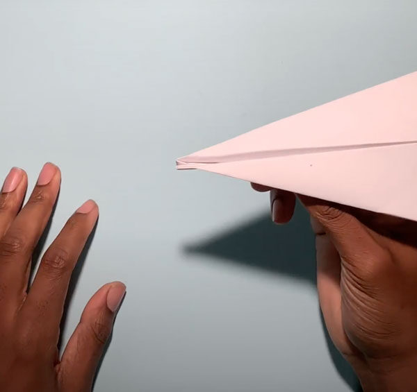 A pair of hands are about to launch a paper airplane