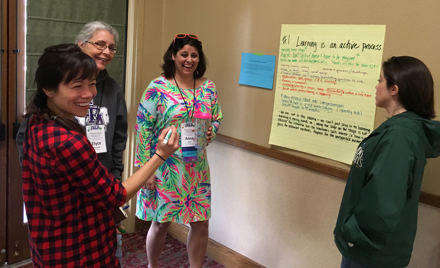 Learning is an active process: four teachers are standing together discussing this topic on a poster