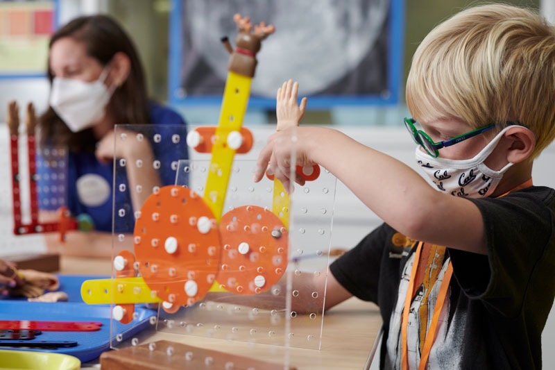 A child works on constructing a project during the Arcade Makers Summer Camp