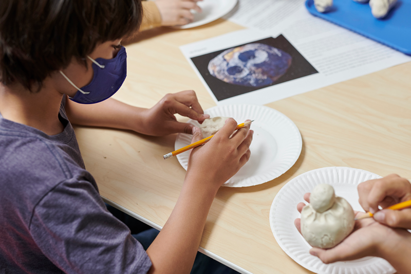 A camper is creating an asteroid during the Asteroid Adventure Summer Camp