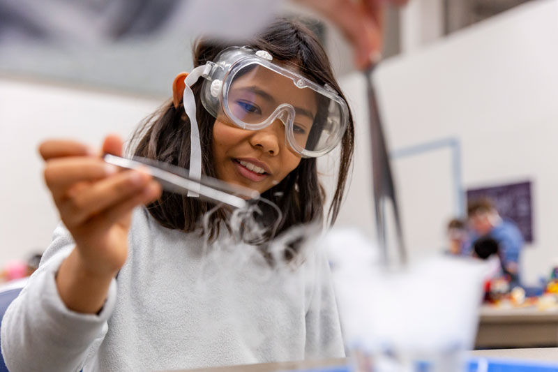 A student conducts a science experiment during Summer Camp