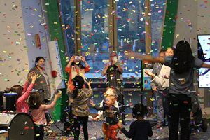 A group gathers to celebrate new years with falling confetti.
