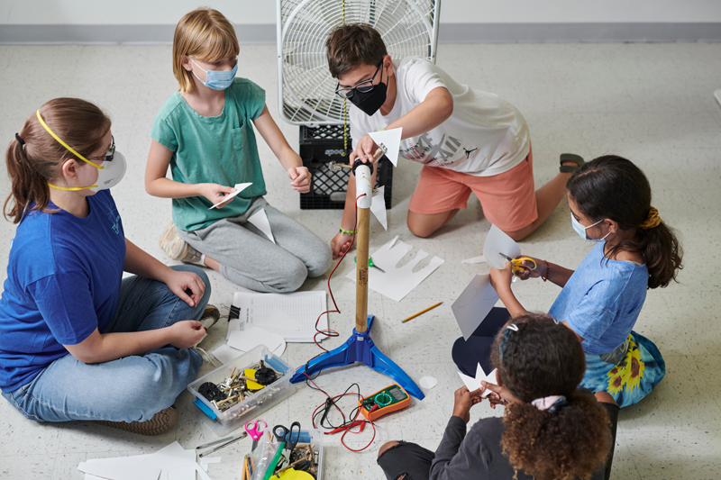 A group of students are collaborating together during a science project at Summer Camp. 
