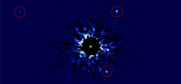 Nearby star called HR 8799, showing its solar system of 4 exoplanets (seen inside red circles). Most of the very bright light from the star itself has been subtracted, in order to be able to see the much fainter planets. The yellow star-shaped marker shows the position of the center of the star.