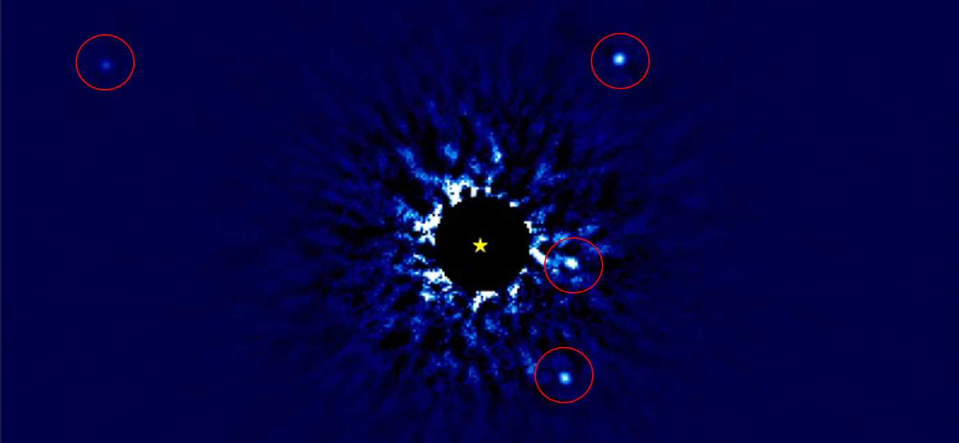 Nearby star called HR 8799, showing its solar system of 4 exoplanets (seen inside red circles). Most of the very bright light from the star itself has been subtracted, in order to be able to see the much fainter planets. The yellow star-shaped marker shows the position of the center of the star.