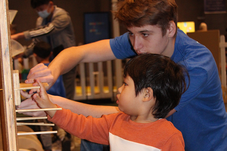 A volunteer and a child work on a science activity together