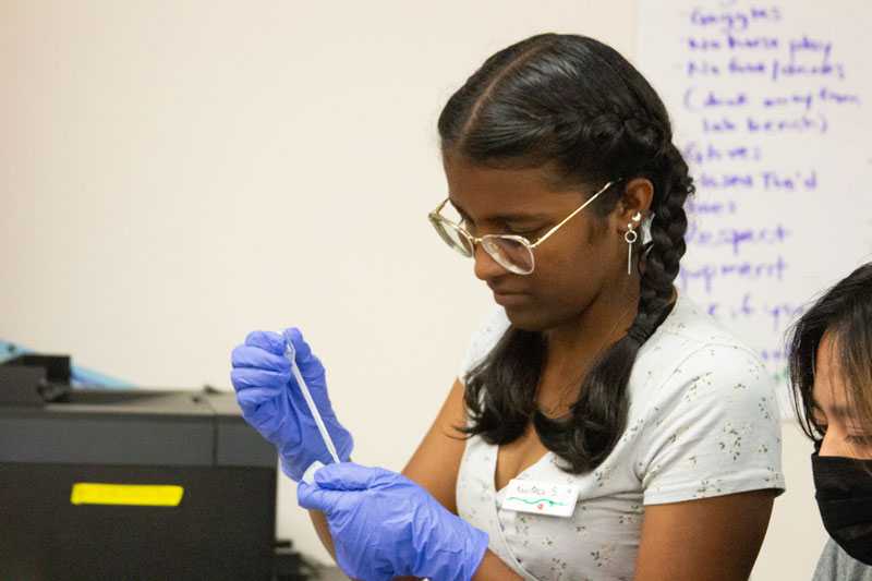 A student conducts a biotech experiment during the Biotech Genetics teen research program