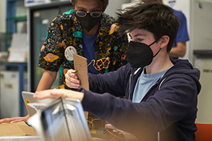 Two students are working on a coding project during the Coding and Engineering Nano-Satellites program.