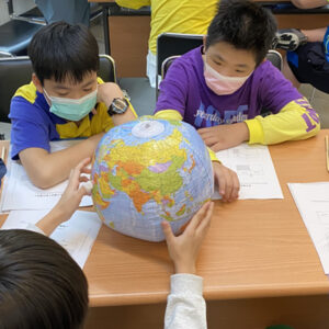 A group of Taiwanese students observing a globe.