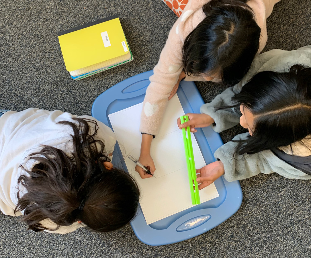 Three students participate in a Make Math REAL activity.