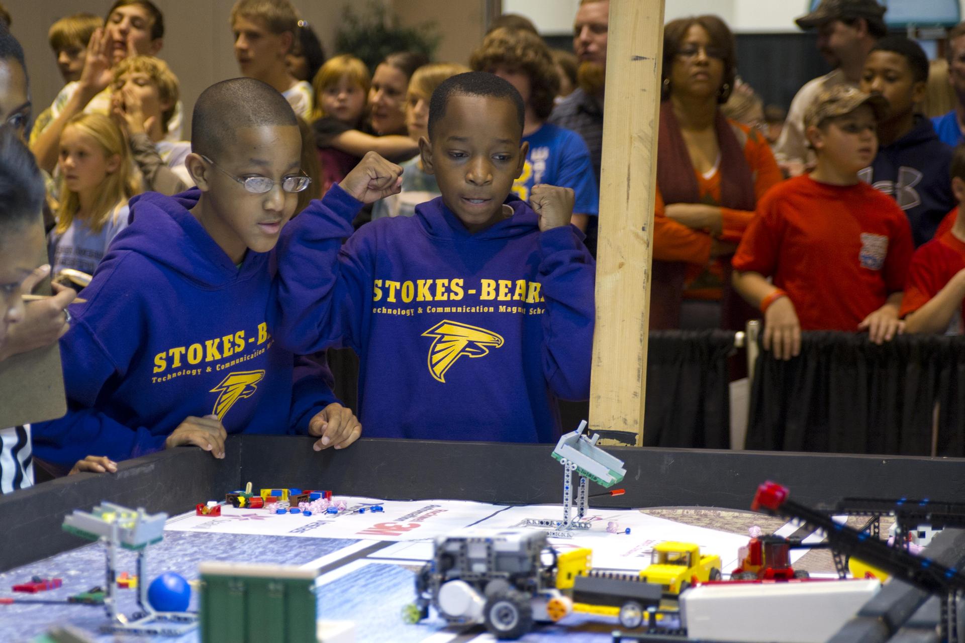 Two Mississippi FIRST LEGO League competitors from Stokes-Beard Magnet Elementary School in Columbus urge their robots on during the annual tournament