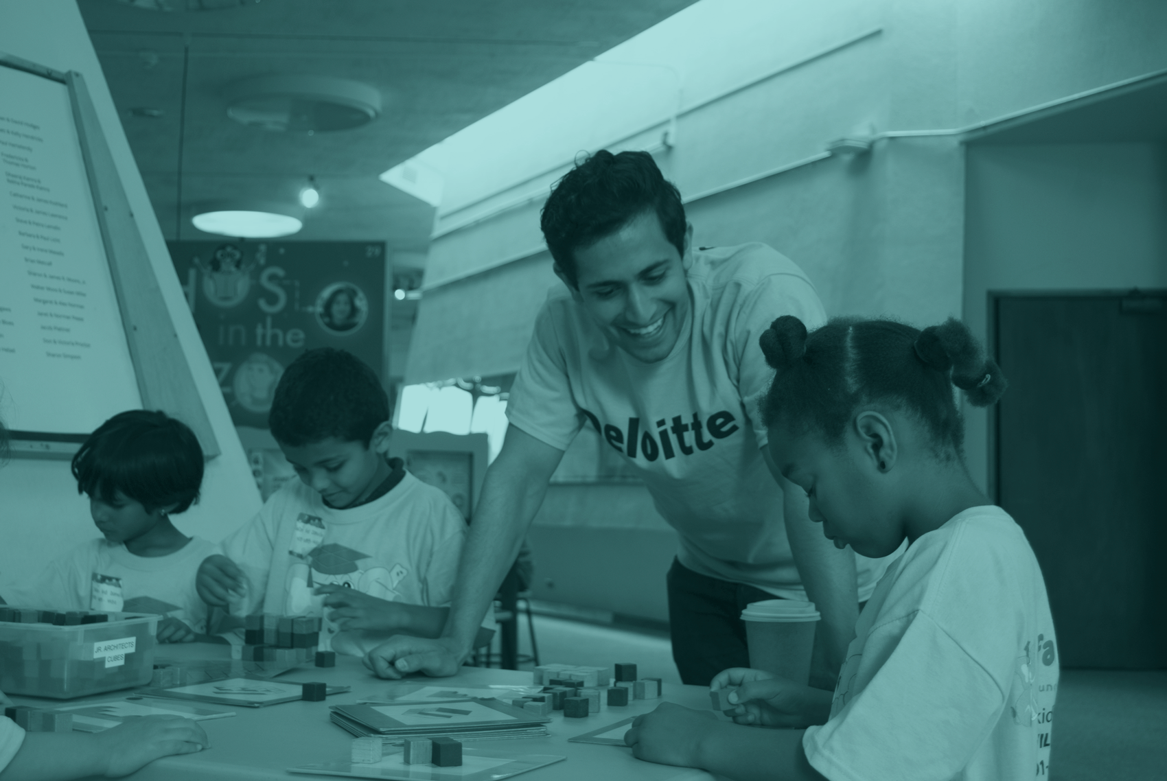 A Deloitte volunteer works with children during a science activity