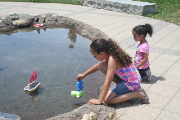 Two girls testing boats made of recycled materials in our Forces That Shape the Bay exhibit