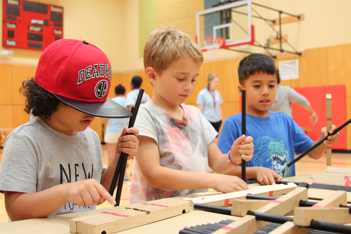 Three students participate in a science festival activity at their school.