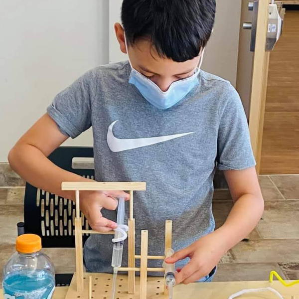 A student constructs an invention during the Make It Move workshop