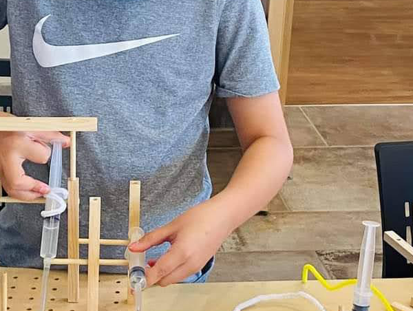 A student constructs an invention during the Make It Move workshop