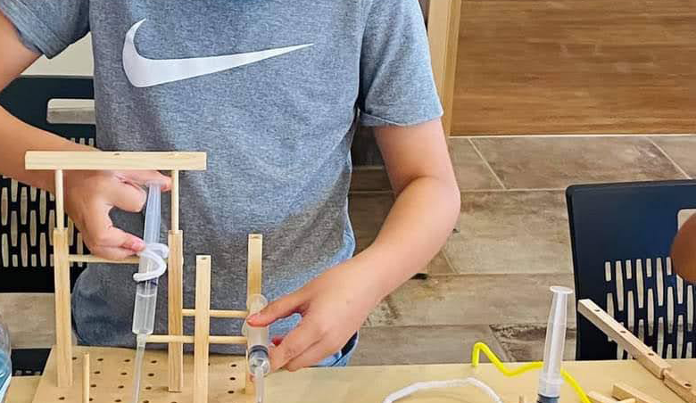 A student constructs an invention during the Make It Move workshop