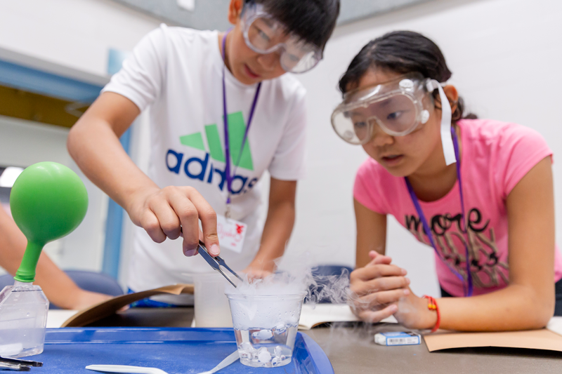 Two students conduct a science experiment with dry ice