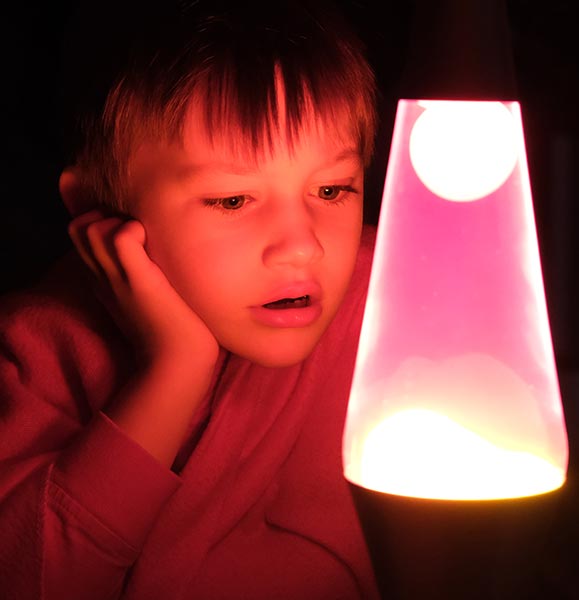 A child is looking at a lava lamp
