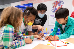 Four students work together on a project during the Creative Contraptions Summer Camp.