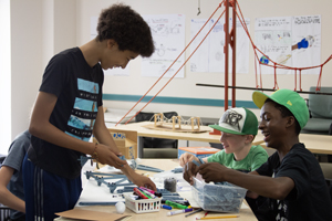 A small group of students build a roller coaster construction project