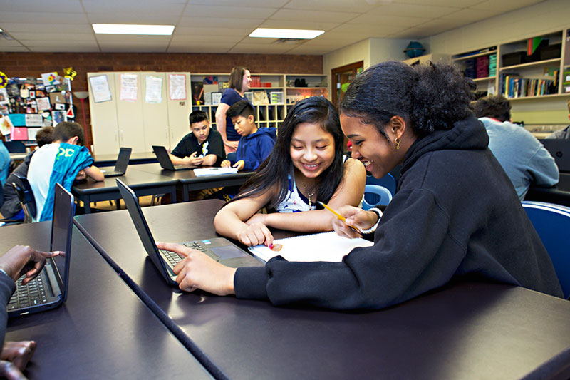 Two students work together on a laptop during group work in the Social Media teen research program