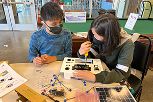 Two students work together on an electrical engineering project.
