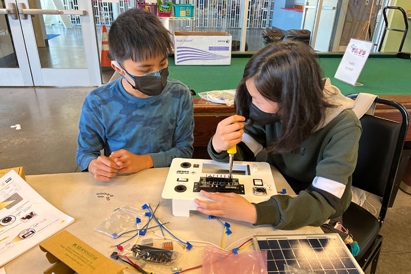 Two students work together on an electrical engineering project.