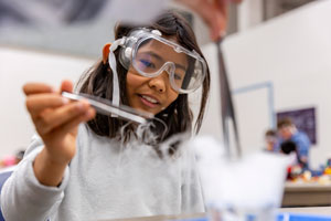 A student conducts a science experiment during Summer Camp.