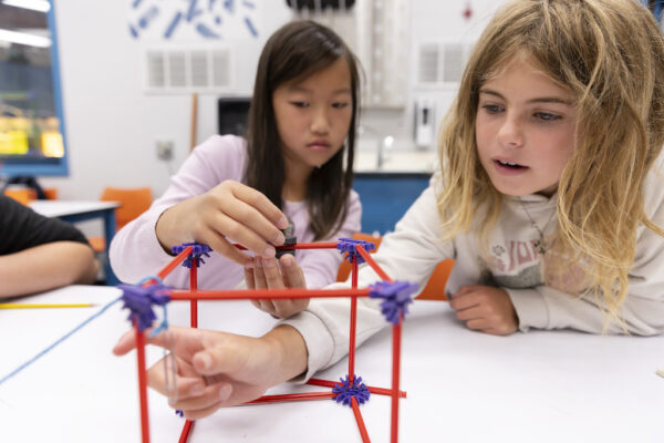 Two girls working on a physics activity in the classroom