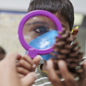 Child looking through a magnifying glass