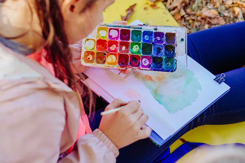 A child paints with watercolors