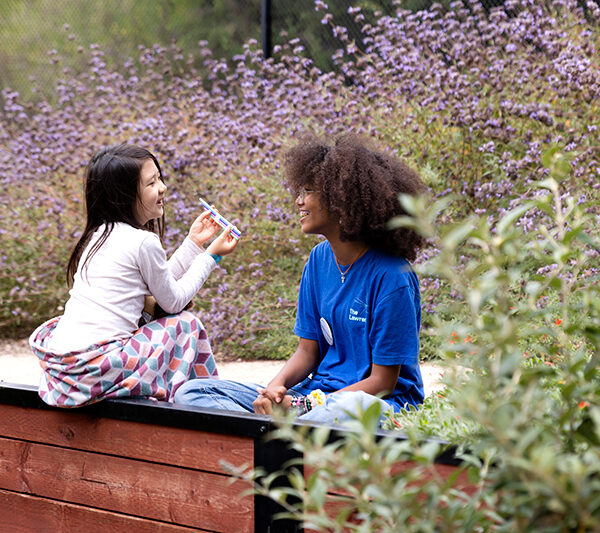 A teen intern interacting with a Lawrence camper in the Outdoor Nature Lab.