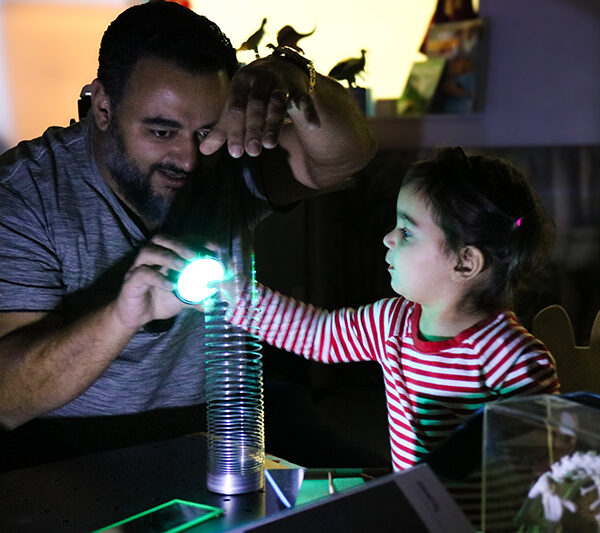 An adult and a child participate in an activity with light in the Dance Into the Light Pilot.