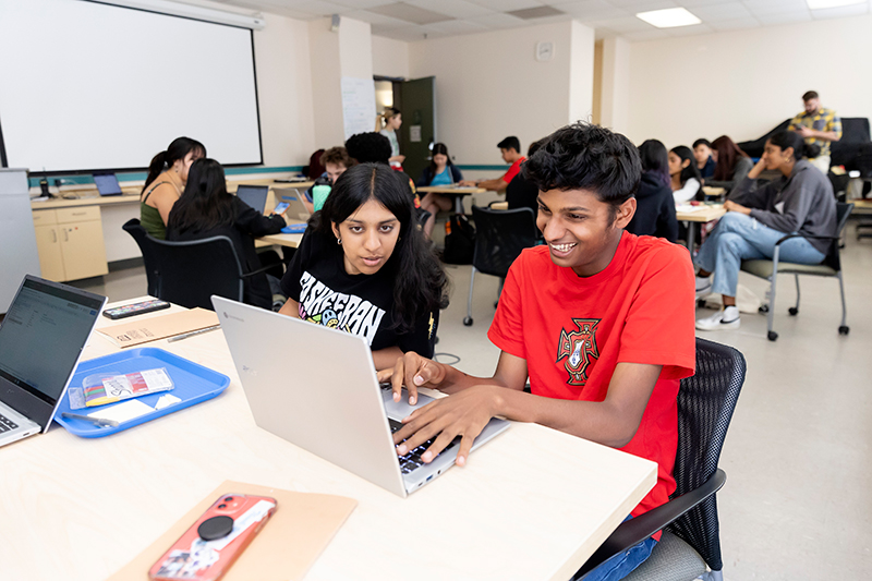 Teen Research Program participants collaborate on a computer