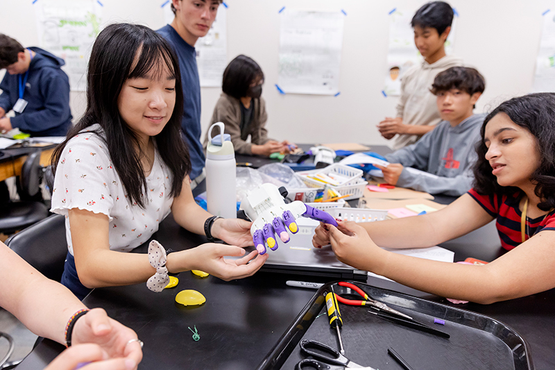 Teen Research Program participants test and decorate a 3D-printed prosthetic hand