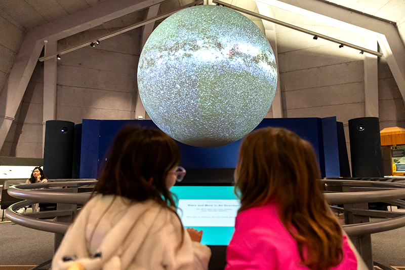 Two young vistors explore Science On a Sphere using the touch screen controls