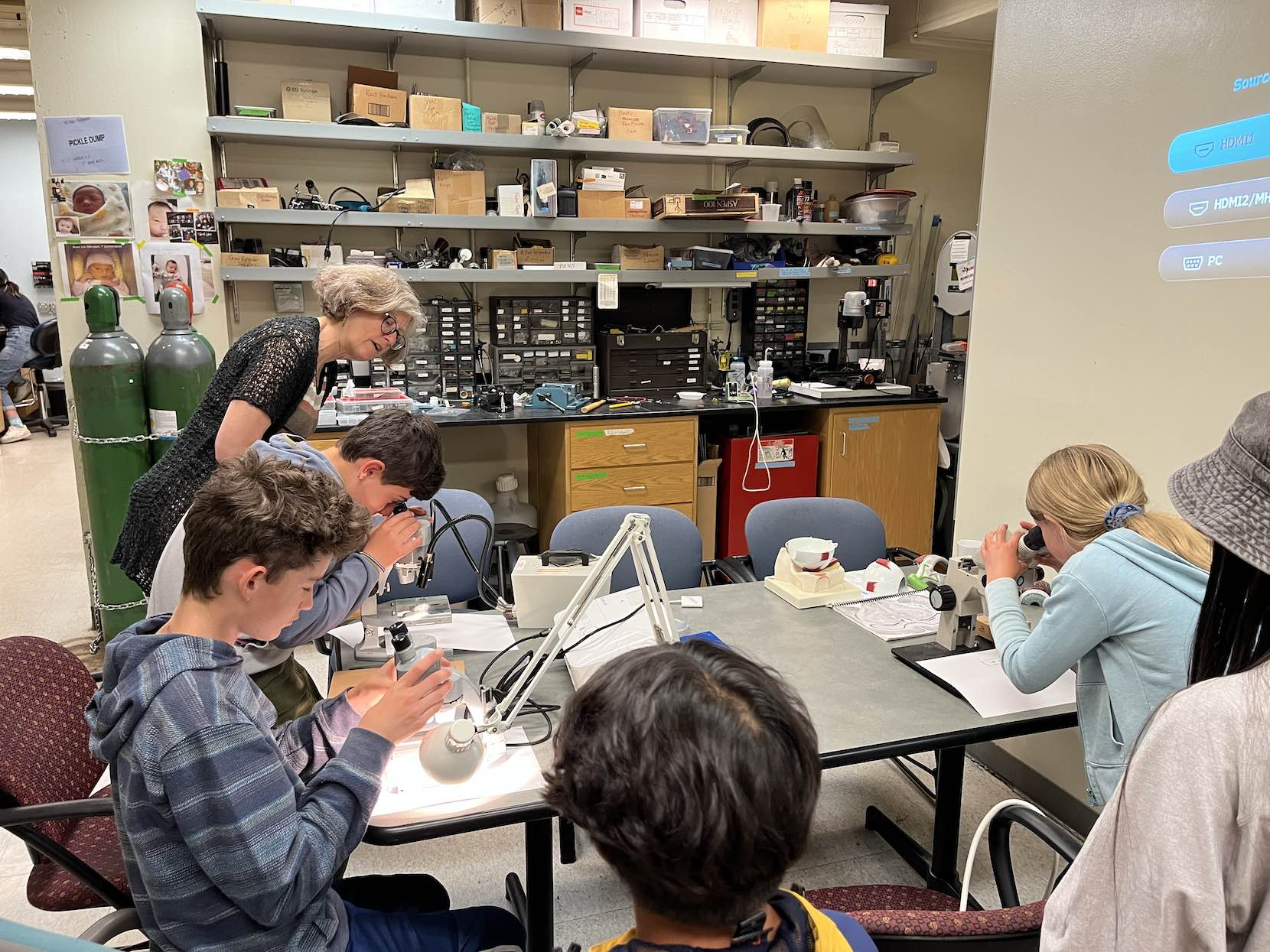 Teens sitting around a table working on a biotech lab.